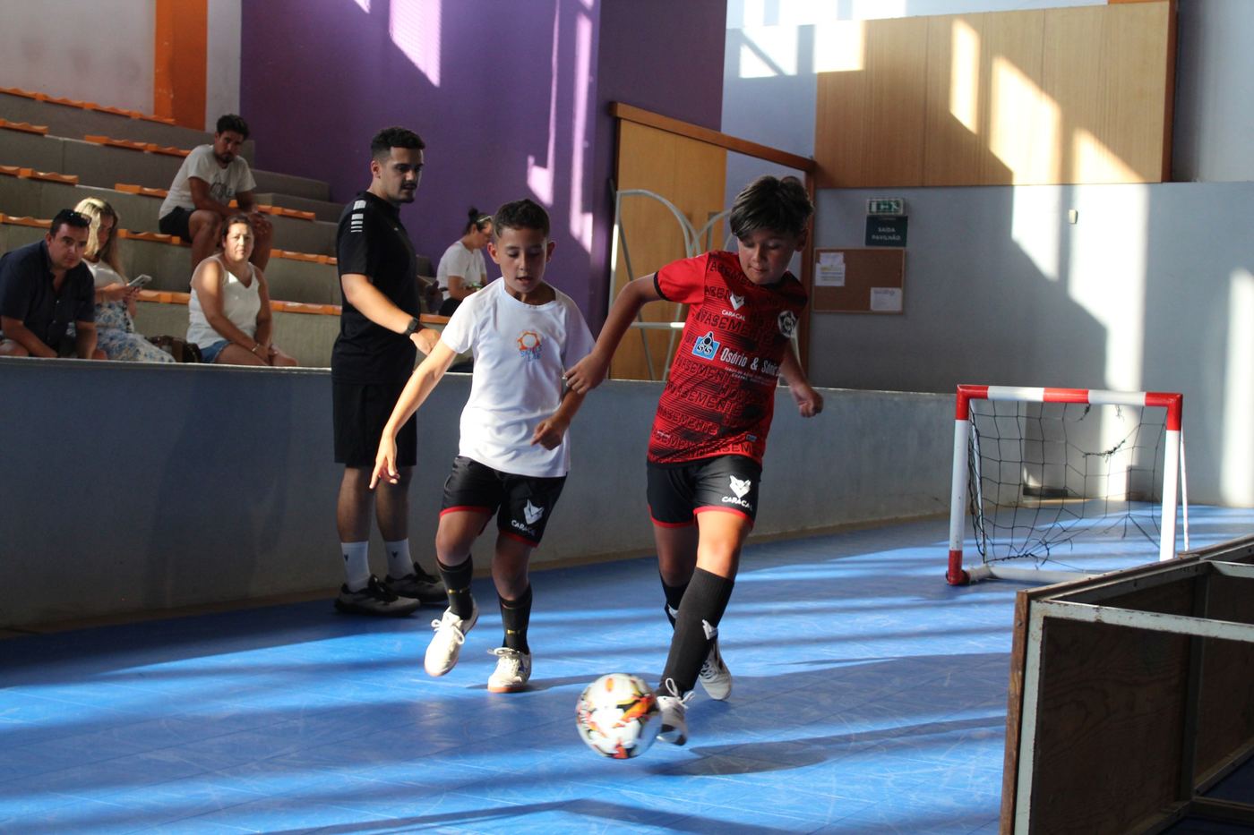 Jogadora a conduzir a bola frente à adversária